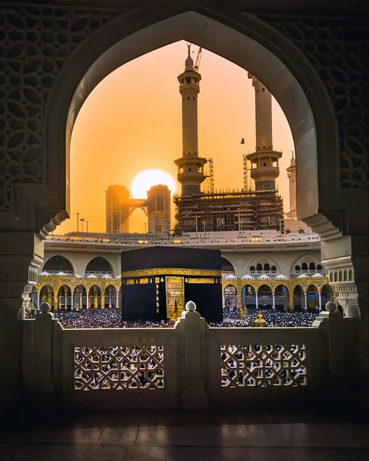 The Kaaba at low sun, seen through an arch of Masjid al-Haram